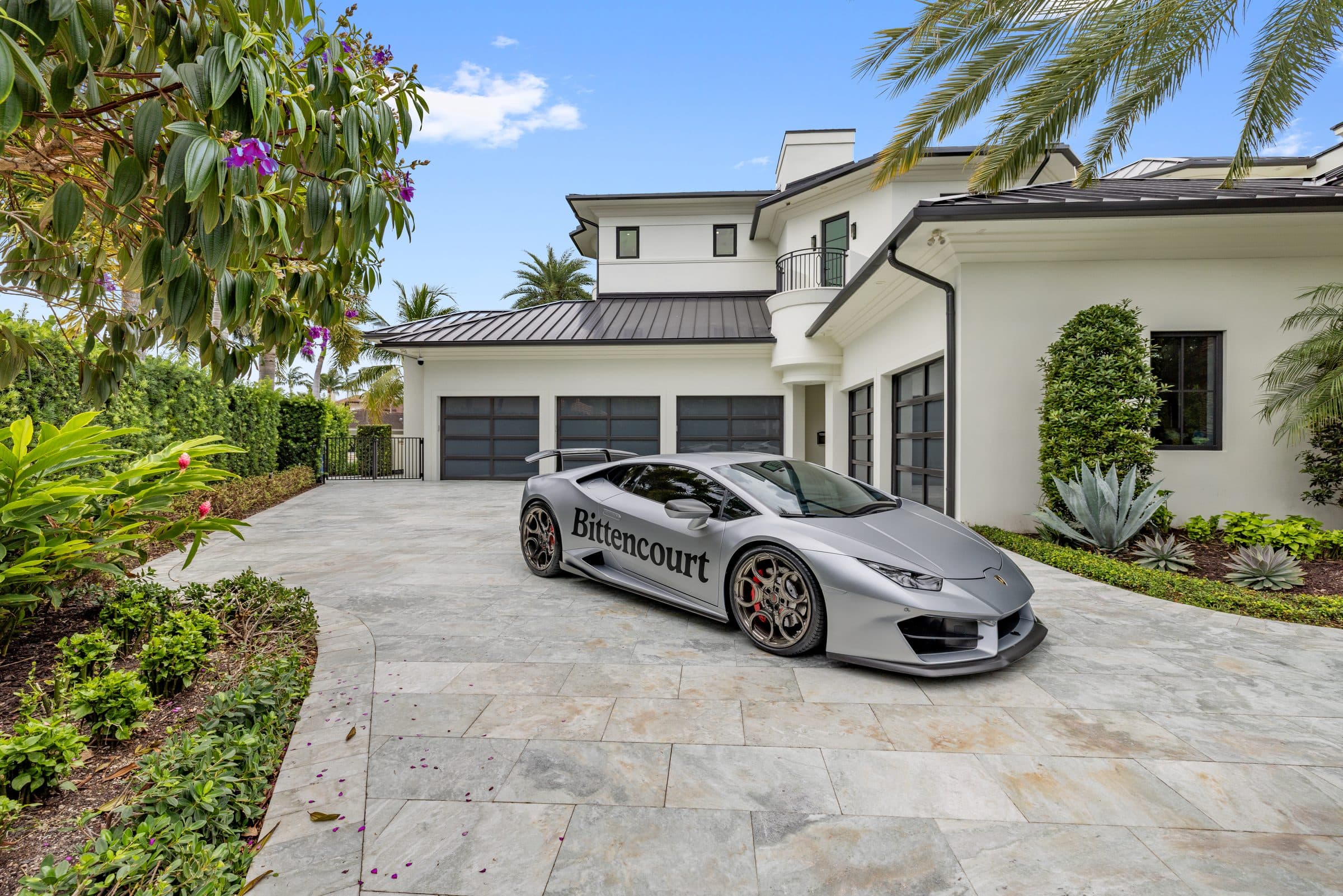 Bittencourt-branded luxury car parked in front of a South Florida residence